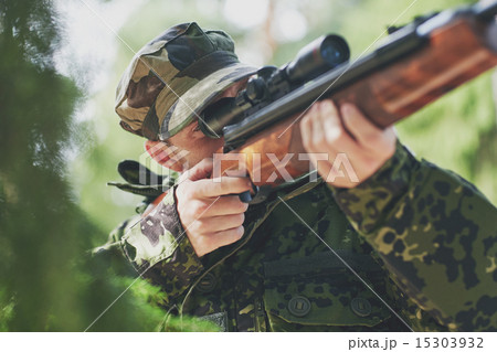 soldier or hunter shooting with gun in forest soldier or hunter shooting with gun in forest 15303932