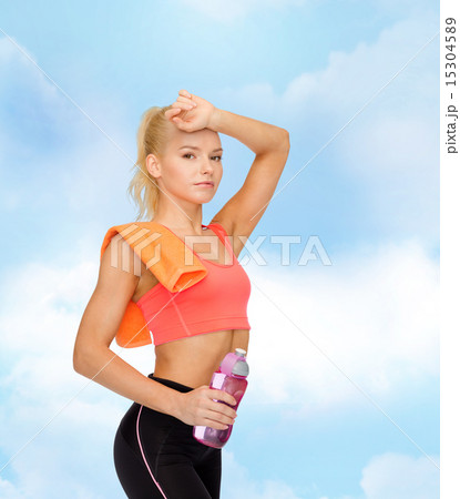 tired sporty woman with towel and water bottle tired sporty woman with towel and water bottle 15304589