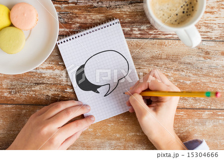 close up of hands drawing text bubble in notebook close up of hands drawing text bubble in notebook 15304666