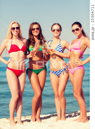 group of smiling young women drinking on beach group of smiling young women drinking on beach 15304711