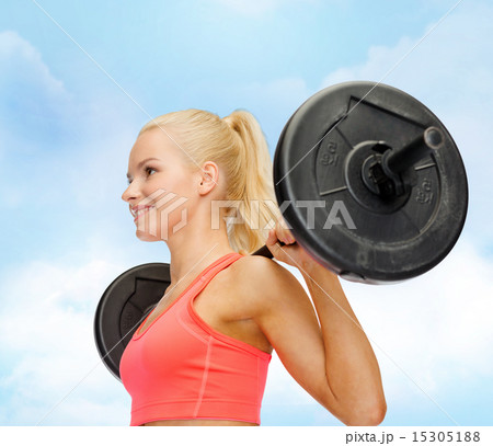 smiling sporty woman exercising with barbell smiling sporty woman exercising with barbell 15305188