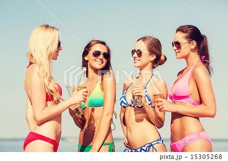 group of smiling young women drinking on beach group of smiling young women drinking on beach 15305268