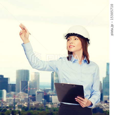 smiling businesswoman in helmet with clipboard smiling businesswoman in helmet with clipboard 15305710