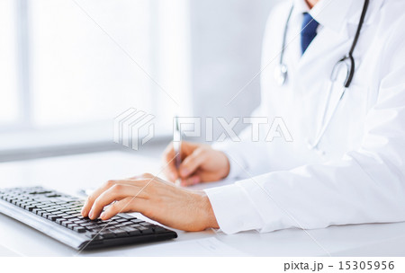 male doctor typing on the keyboard male doctor typing on the keyboard 15305956