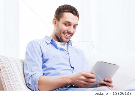 smiling man with tablet pc and cup at home smiling man with tablet pc and cup at home 15306138