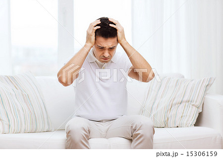unhappy man suffering from head ache at home unhappy man suffering from head ache at home 15306159