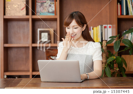 ノートパソコンを見る本棚の前の女性 ノートパソコンを見る本棚の前の女性 15307445