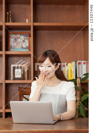 ノートパソコンを見る本棚の前の女性 ノートパソコンを見る本棚の前の女性 15307446