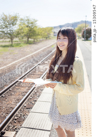 駅のホームで電車を待つ可愛い女の子の写真素材