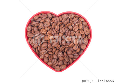Coffee beans in a dish in the shape of a heart. 15318353