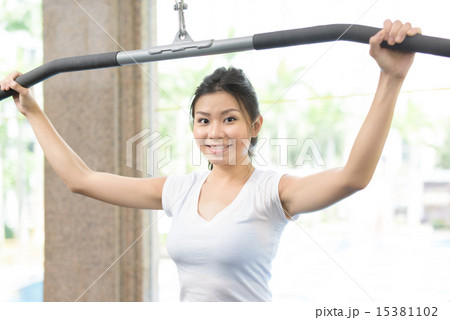 Young Chinese woman using fitness machine 15381102