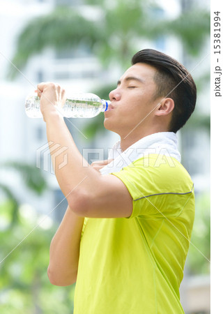 Young Chinese man hydrating himself after exercise Young Chinese man hydrating himself after exercise 15381994