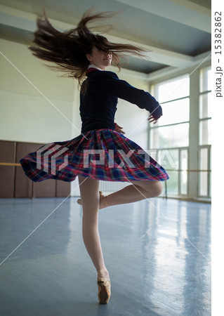 Long-haired ballerina spins in the dance moves on one leg to sta Long-haired ballerina spins in the dance moves on one leg to sta 15382862