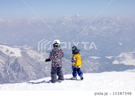 信州の美しい山々を眼前に見ながらゲレンデに立つチビッ子スノーボーダー 15387346