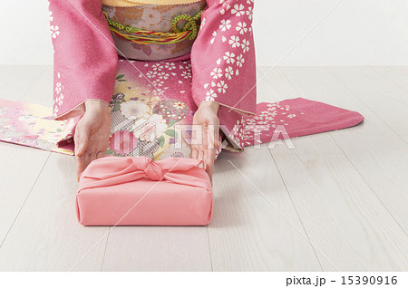 贈り物を届ける着物女性手元 15390916