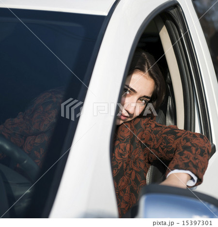 Young pretty smiling girl sitting behind the wheel of a car 15397301