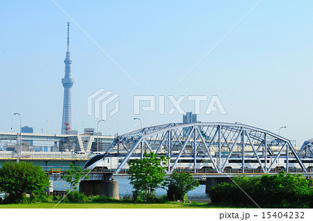 青空と東京スカイツリーをバックに荒川橋梁を渡る京成スカイライナー 15404232