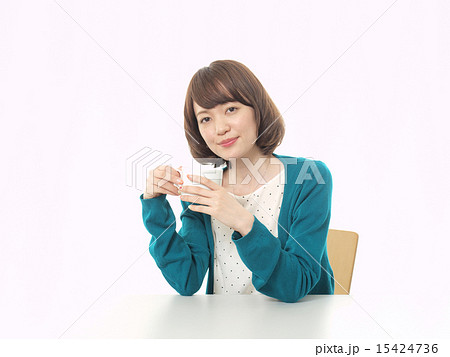 両手で白いコーヒーカップを持つ女性の写真素材