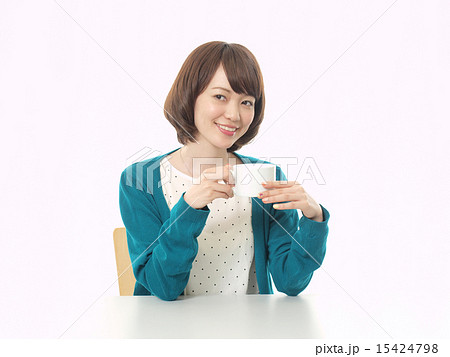 両手で白いコーヒーカップを持つ女性の写真素材