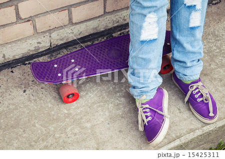 Teenager in gumshoes stands with skateboard Teenager in gumshoes stands with skateboard 15425311