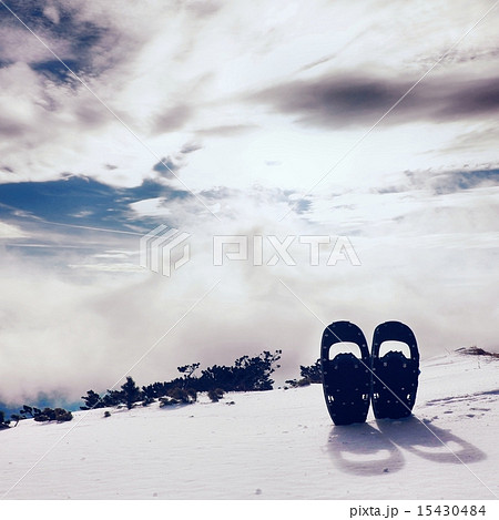 Snowshoes in snow at mountain peak, winter day 15430484