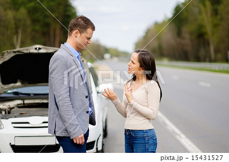 Couple near broken car on a highway roadside Couple near broken car on a highway roadside 15431527
