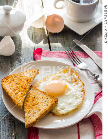 crispy toast with a fried egg and a cup of coffee crispy toast with a fried egg and a cup of coffee 15431896