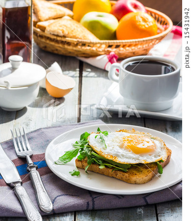 crispy toast with a fried egg and green arugula crispy toast with a fried egg and green arugula 15431942