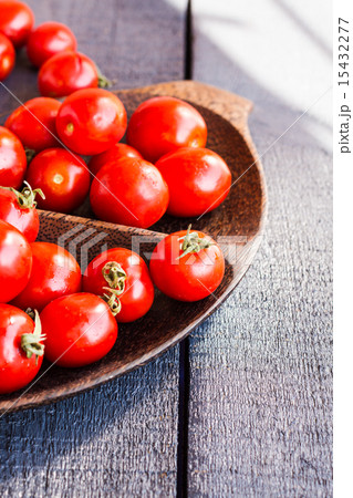red juicy tomatoes cherry in brown wooden plate 15432277