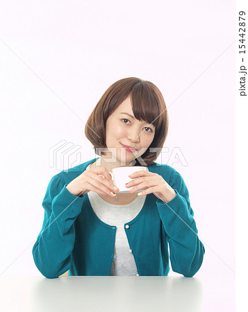 両手で白いコーヒーカップを持つ女性の写真素材