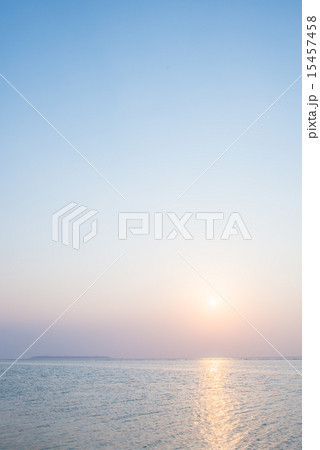 沖縄の海 夕日と淡い空の写真素材