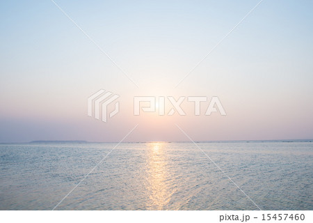 沖縄の海 夕日と淡い空の写真素材