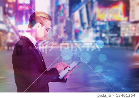 Composite image of businessman in reading glasses using his tabl 15461254