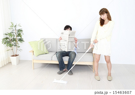掃除をする女性と新聞を読む男性 掃除をする女性と新聞を読む男性 15463607