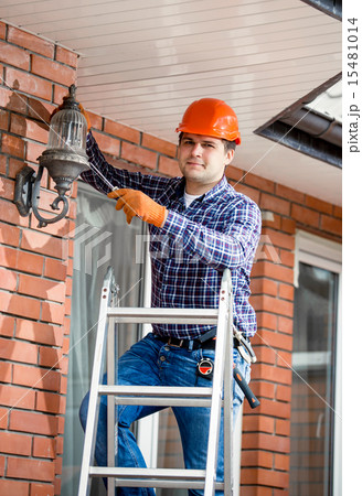 man changing bulb at outdoor lamp man changing bulb at outdoor lamp 15481014