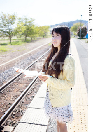 田舎の無人駅で電車を待つ若い女性 15482328
