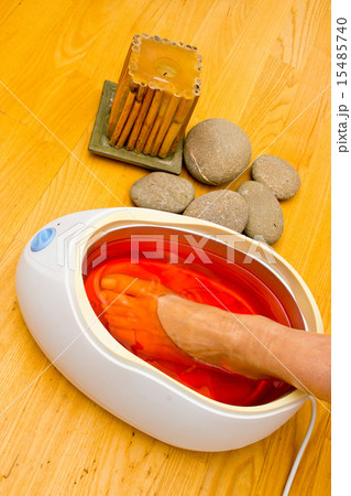 woman foot in paraffin bath at the spa 15485740