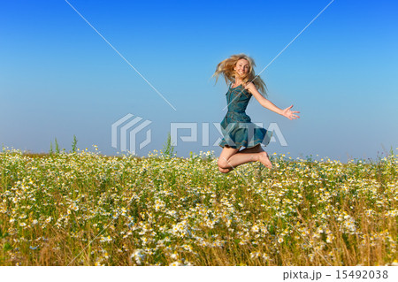 The happy young woman jumps in the field of camom The happy young woman jumps in the field of camom 15492038