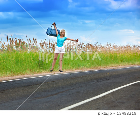 Hitchhiking girl votes on road 15493219