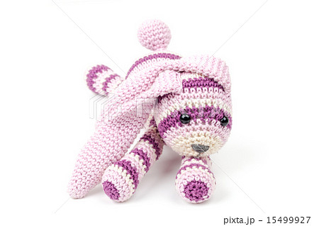 Knitted pink rabbit toy lays isolated on white 15499927