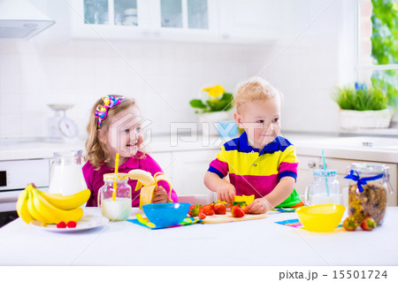 Kids preparing breakfast in a white kitchen Kids preparing breakfast in a white kitchen 15501724