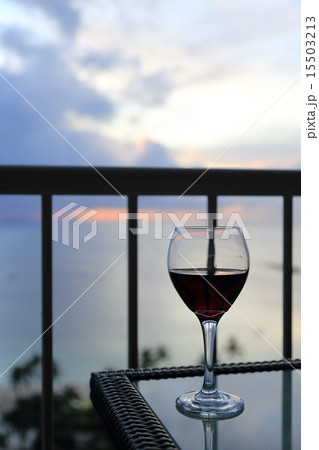 夕暮れにビーチサイドテラスで飲む赤ワイン 15503213