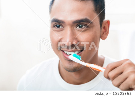 Asian man brushing teeth Asian man brushing teeth 15505362