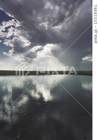 The reflection of a dramatic sky in the flat surface of a lake. 15519361