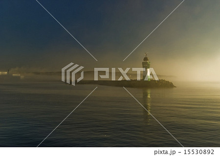 silhouette of lighthouse in fog at sunrise 15530892