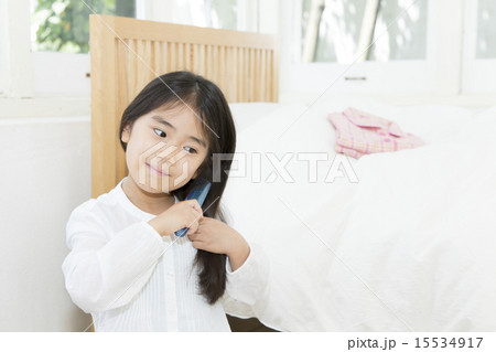 髪の毛をとかす女の子の写真素材