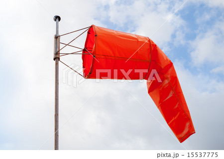 Windsock. Red wind indicator over cloudy sky Windsock. Red wind indicator over cloudy sky 15537775