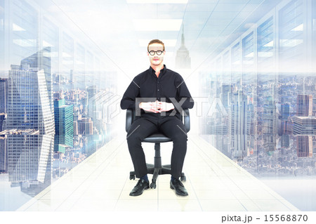 Composite image of stern businessman sitting on an office chair 15568870