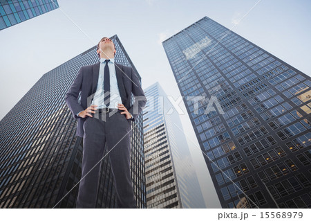 Composite image of serious businessman with hands on hips Composite image of serious businessman with hands on hips 15568979