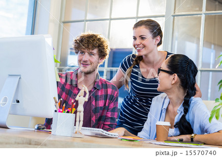 Smiling partners working together on computer Smiling partners working together on computer 15570740